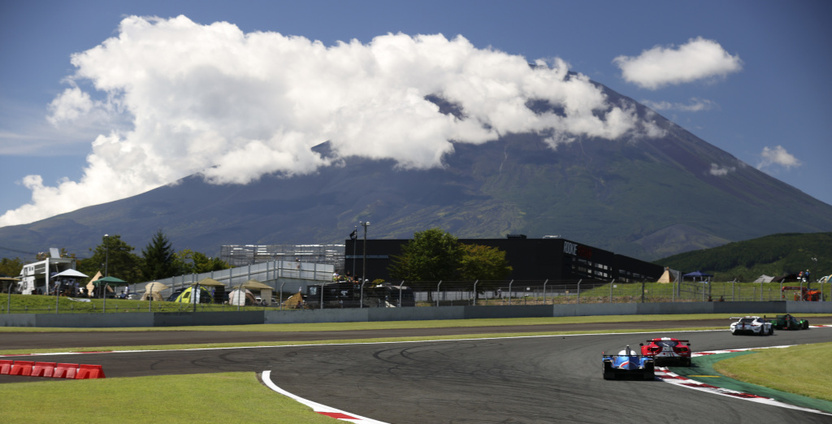 A Toyota Gazoo racing car on track in front of Mount Fuji in the background