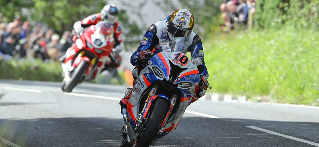 A man on a motorcycle races through the streets during the Isle of Man TT