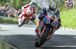 A man on a motorcycle races through the streets during the Isle of Man TT