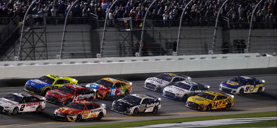 Ten cars form a pack racing up to three-wide during a Nascar race at Daytona